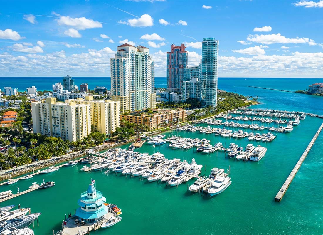 Contact - Aerial View of Yachts on the Water Next to Commercial Buildings on a Sunny Day in Miami