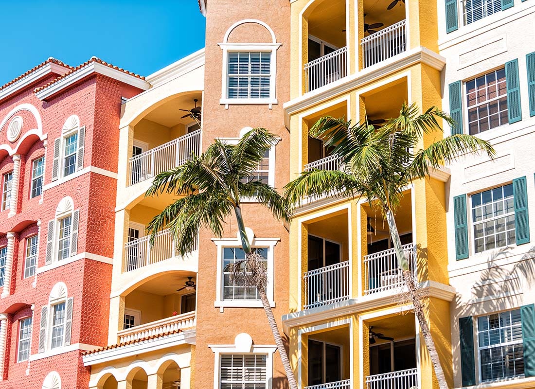 Insurance by Industry - View of a Colorful Condominium Building in South Florida with Palm Trees